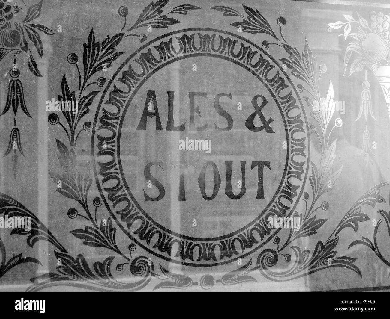 Old ales and stout advertisement sign etched into public house window Stock Photo