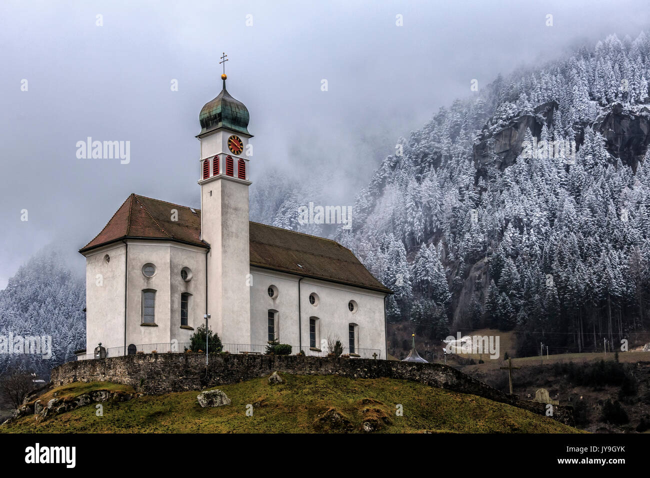 The Church of Wassen at San Gottardo after a recent snowfall that has whitened the fir trees behind it. Andermatt. Canton of Uri. Switzerland. Europe Stock Photo