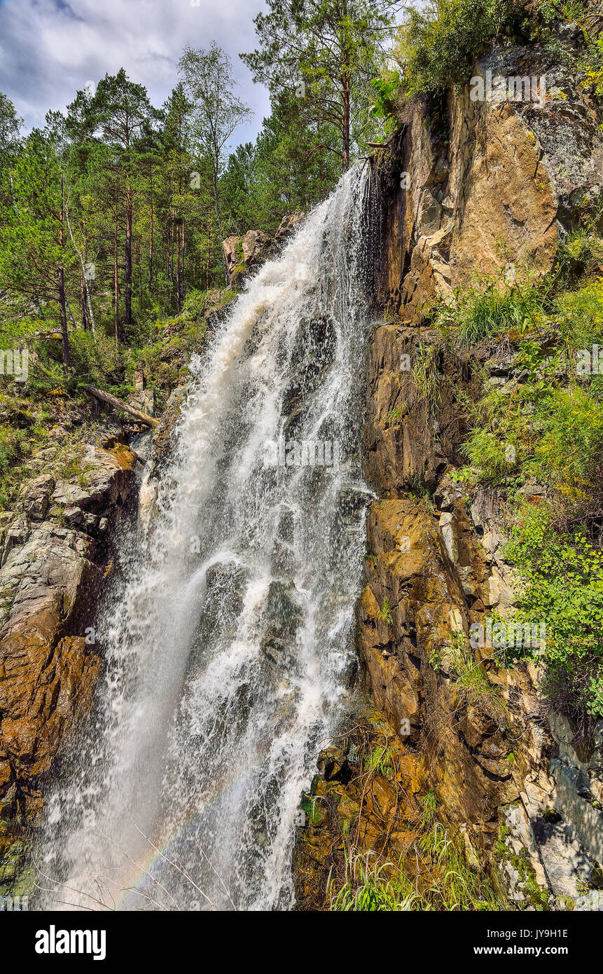 Summer mountain landscape of Kamyshlinsky waterfall with raibow in rocks of Altai mountains, Altay Republic, Siberia, Russia. Stock Photo