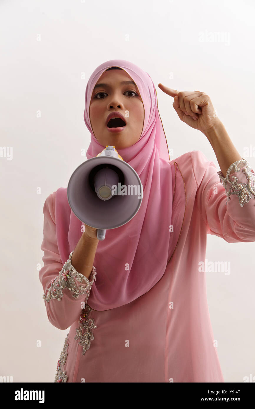 malay woman speaking into a megaphone making a public announcement
