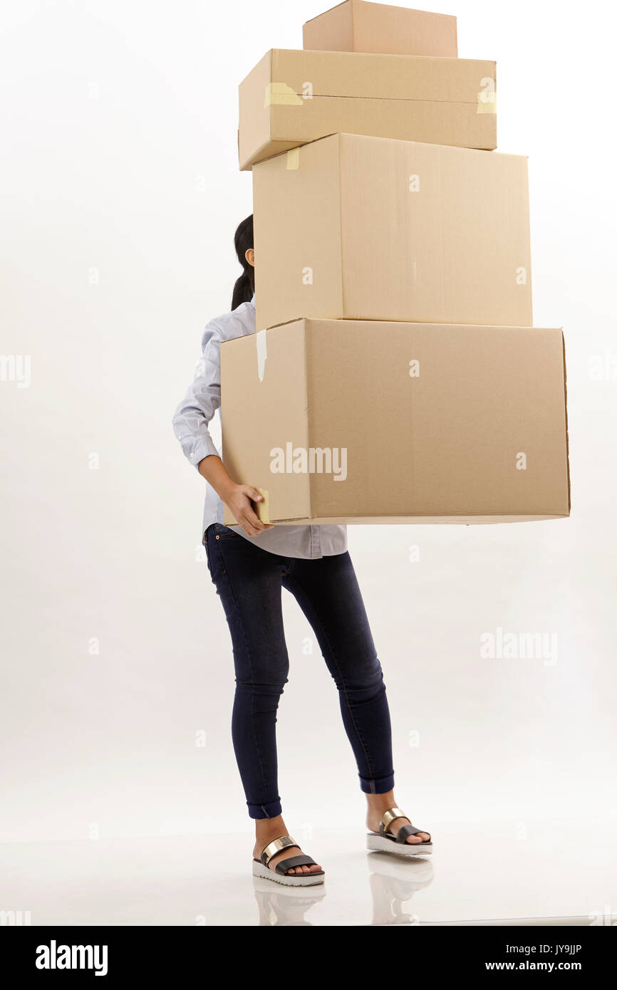 woman carring stack of brown boxes she hiding behind boxes Stock Photo