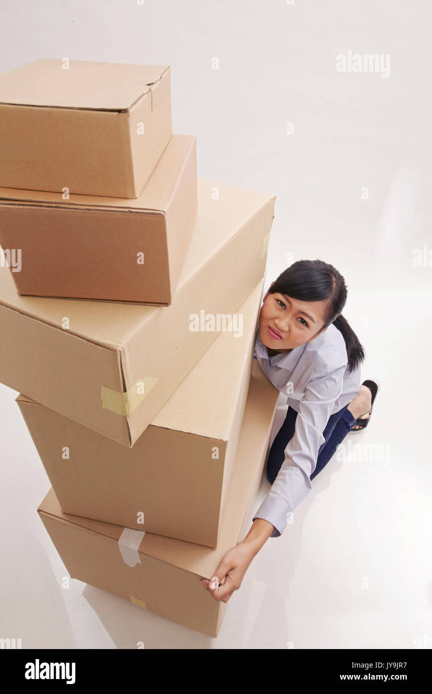 high angle view of asian woman lifting stack of boxes Stock Photo - Alamy