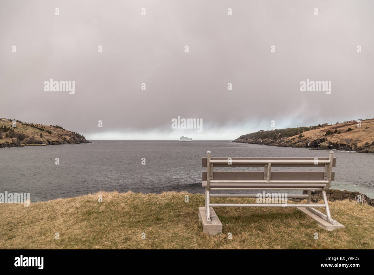 Large iceberg on the sea under storm clouds in Torbay, Newfoundland