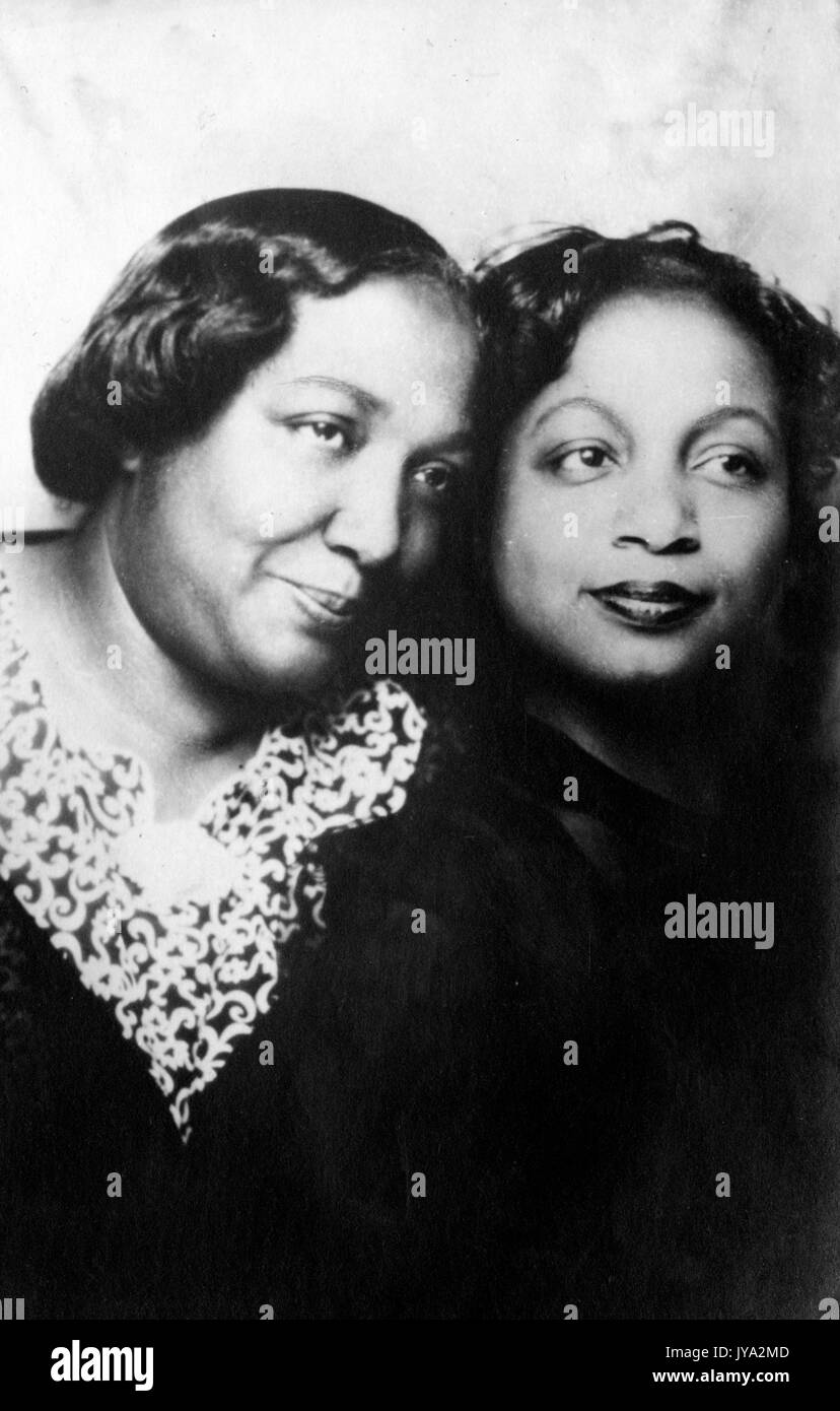 Two African-American adult sisters, half length portrait, close up, the two sisters standing with their heads touching and looking off the frame, 1950. Stock Photo