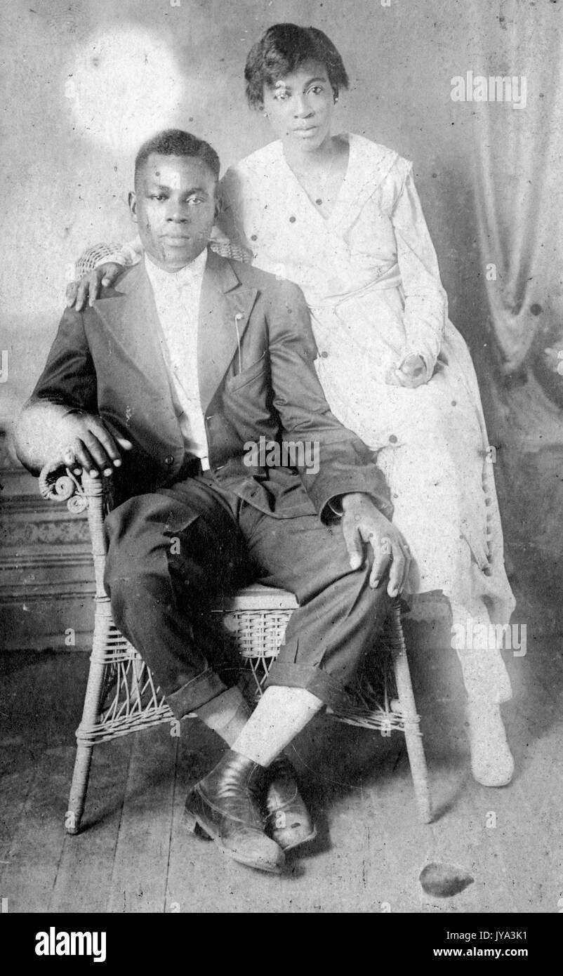 young-african-american-couple-the-man-sitting-in-a-wicker-chair-and-JYA3K1.jpg