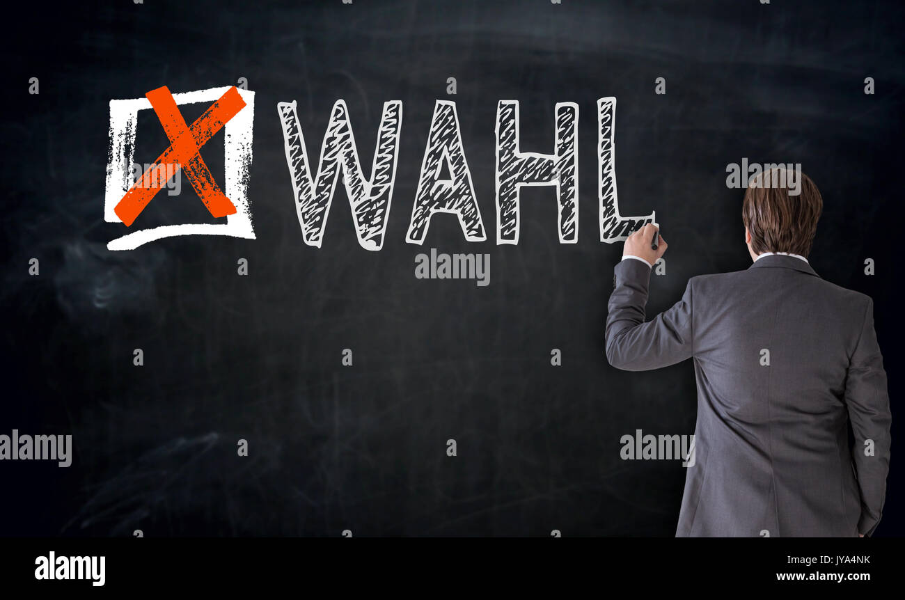 Businessman writes Wahl (in german Vote) on blackboard concept. Stock Photo