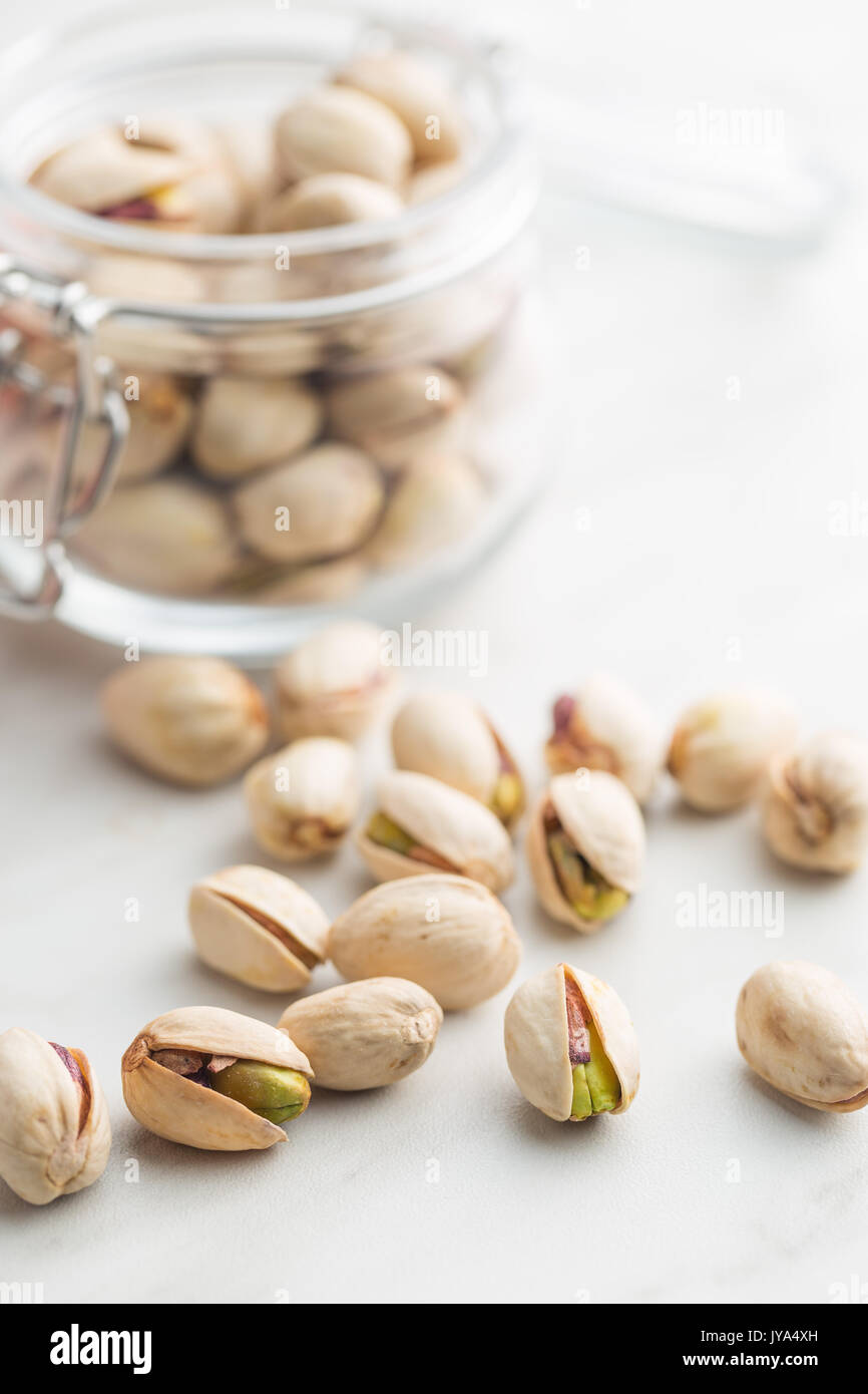 Dried pistachio nuts in jar on kitchen table. Pistachio kernel Stock