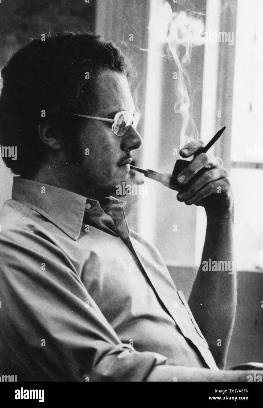 Patrick Oliphant smoking a pipe, 1975. Stock Photo