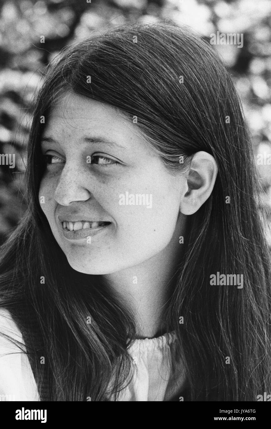 A portrait photograph of a female undergraduate student at Johns Hopkins University sitting outside on campus during the first years of the undergraduate program's admittance of women, in Baltimore, Maryland. 1970. Stock Photo
