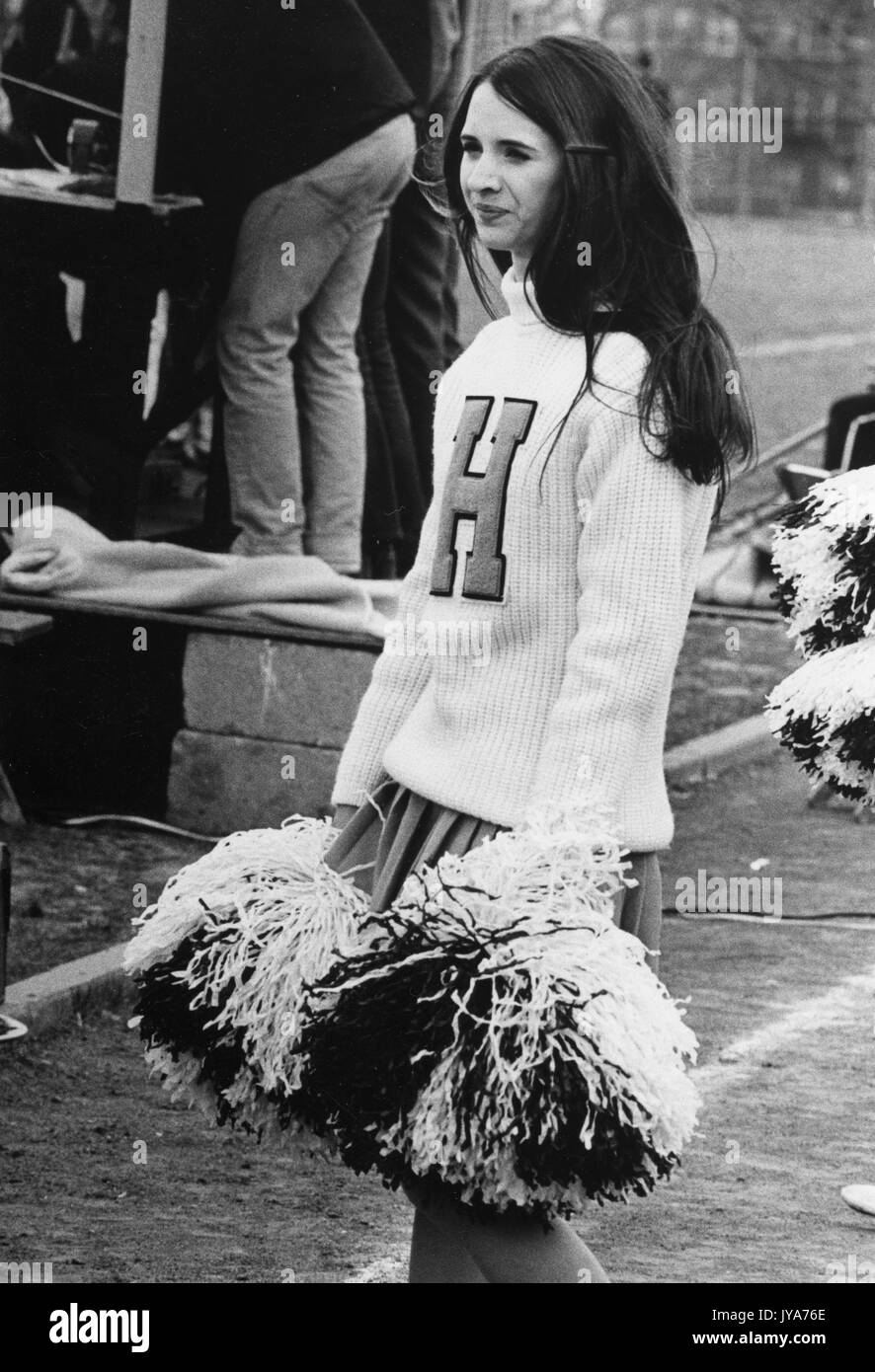 A female undergraduate student at Johns Hopkins University cheerleads during a sporting event on the Homewood campus in Baltimore, Maryland during the first years that the university's undergraduate program admitted women. 1970. Stock Photo