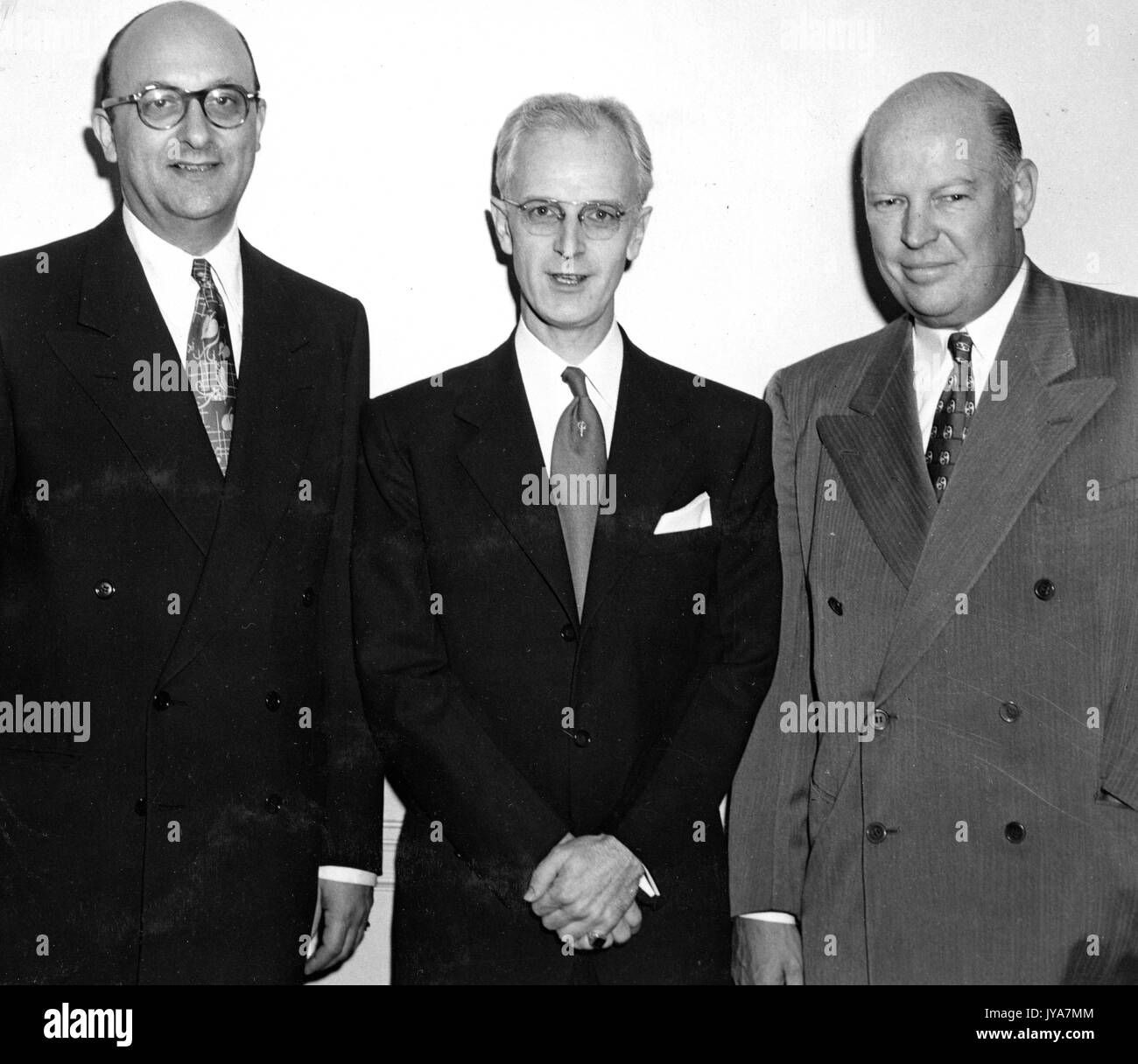 Executive Ben Cohen, American television host Lynn Poole, and Dr Allen B DuMont are standing in order from left to right, they are all wearing business suits and ties, they are smiling for the camera, 1950. Stock Photo