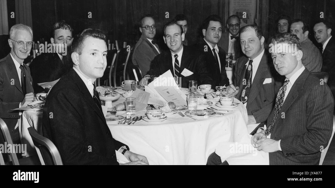 Colleagues at Alumni Banquet, including Arthur Sarnoff (near side, left), at the time a recent graduate and permanent class president of the Johns Hopkins University; American television host Lynn Poole (back, far left); plant biochemist Al Nason (far back, center); Paul Kane (front center of far table), director of the Johns Hopkins Science Review; biochemist William D McElroy (in bow tie at center back of far table); Robert Fenwick (far back, second from left), associate producer for WAAM Baltimore; Glenn Lehman (front table, center), chief engineer for WAAM Baltimore; Ben Wolfe (front table Stock Photo
