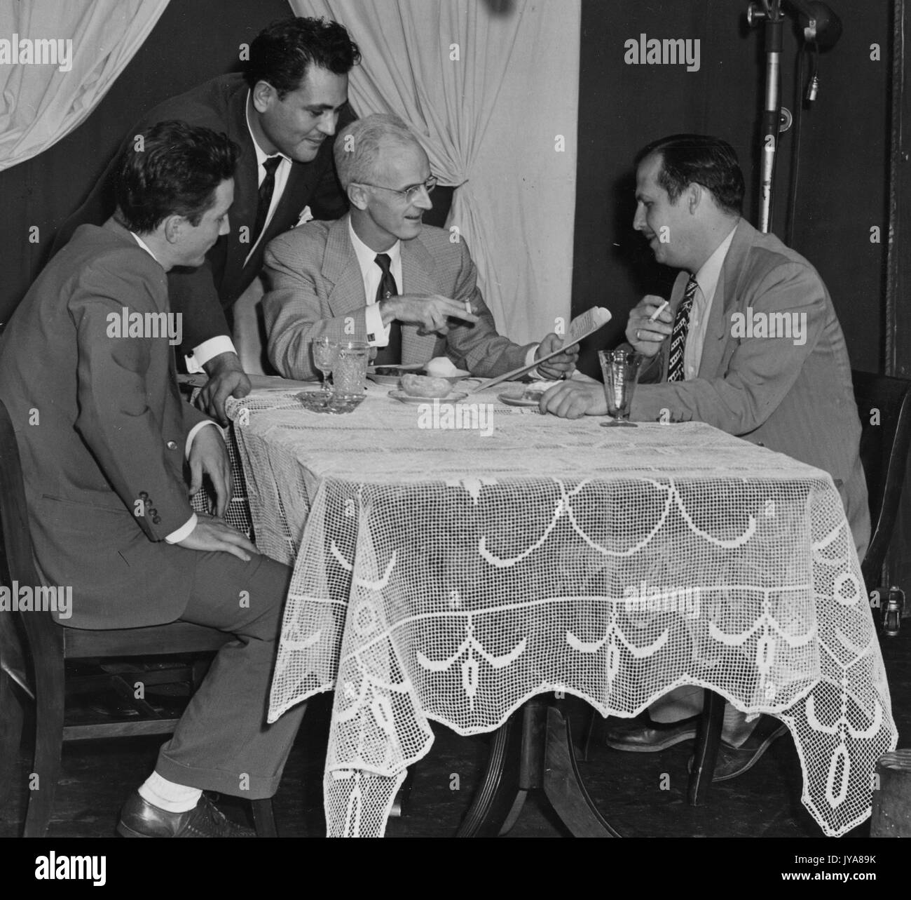 Set of the 'Are You Too Fat?' segment of the Johns Hopkins Science Review, featuring (clockwise from left) Warren Wightman, producer of the Johns Hopkins Science Review; Paul Kane, director of the Johns Hopkins Science Review; American television host Lynn Poole; and Robert Fenwick, associate producer for WAAM Baltimore, September 29, 1952. Stock Photo