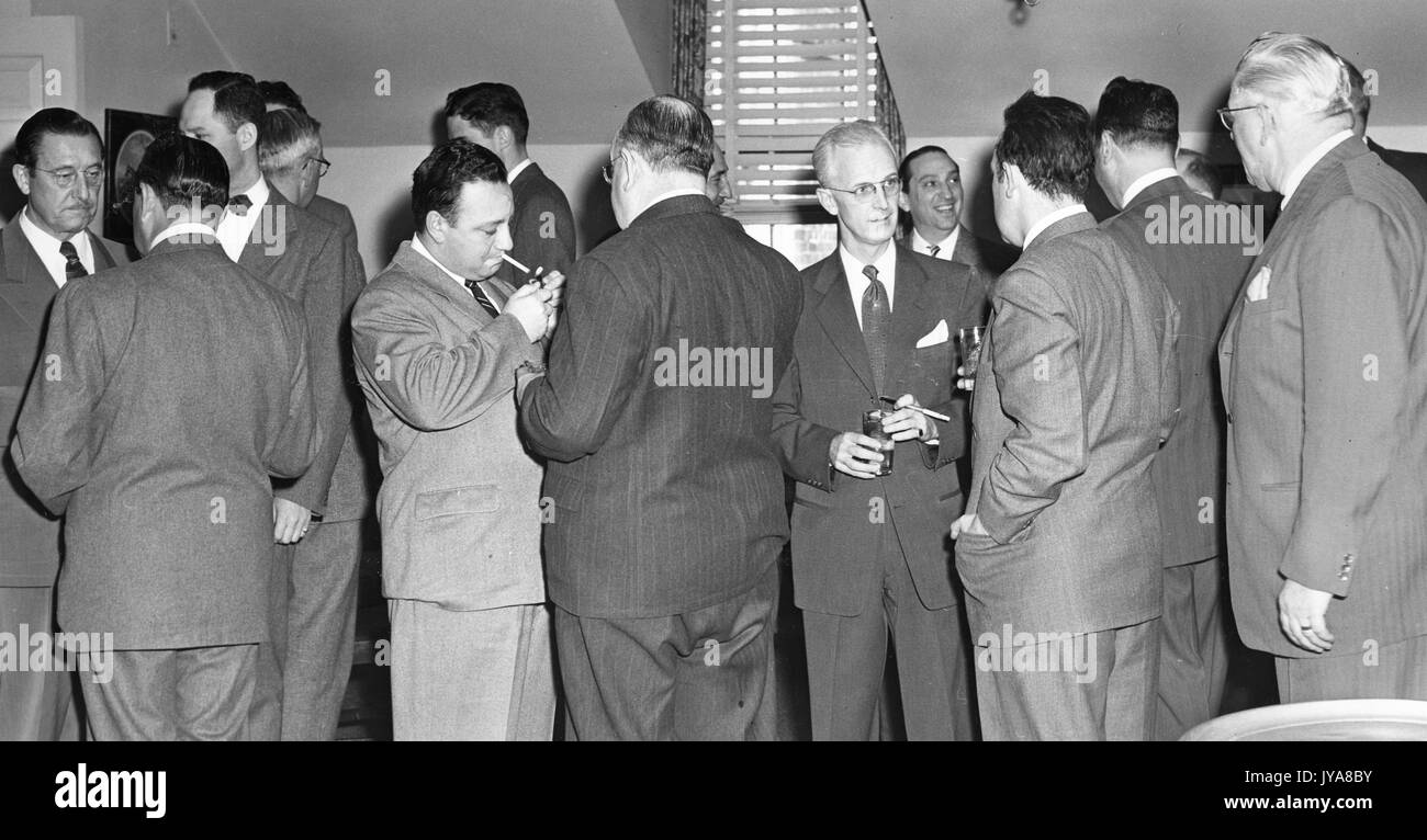 Standing group shot of men, including American television host Lynn Pool, engaged in conversation during a luncheon at the Second Annual Regional Television Review at Baltimore, 1952. Stock Photo