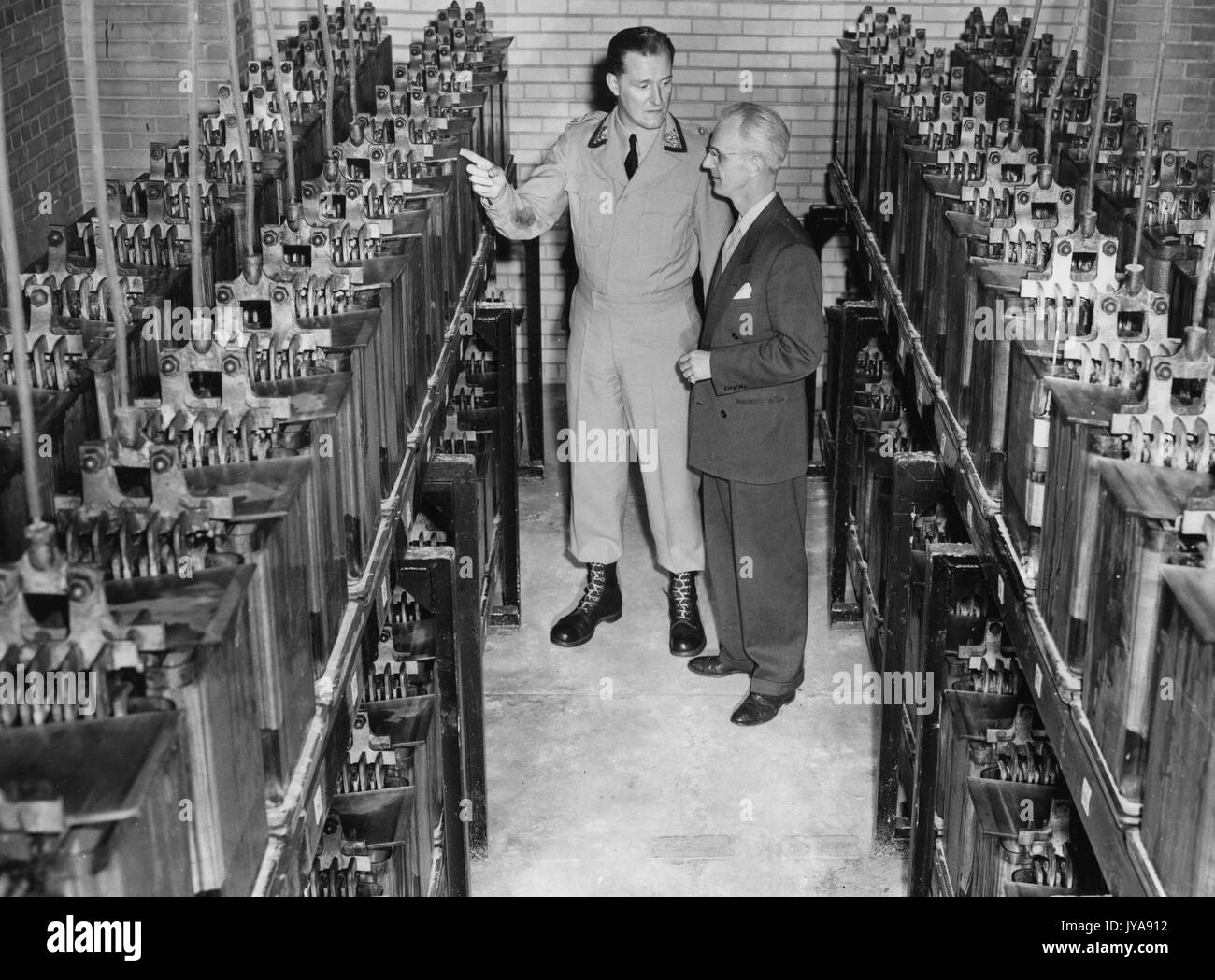 American television host Lynn Poole and guest on set of the Johns Hopkins Science review television program, inspecting industrial electric switching equipment, 1951. Stock Photo