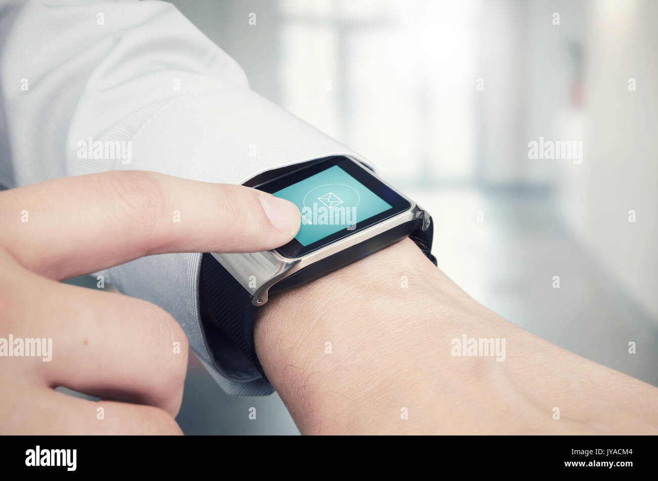 Businessman checking e-mail on modern smart watch. Office in background Stock Photo