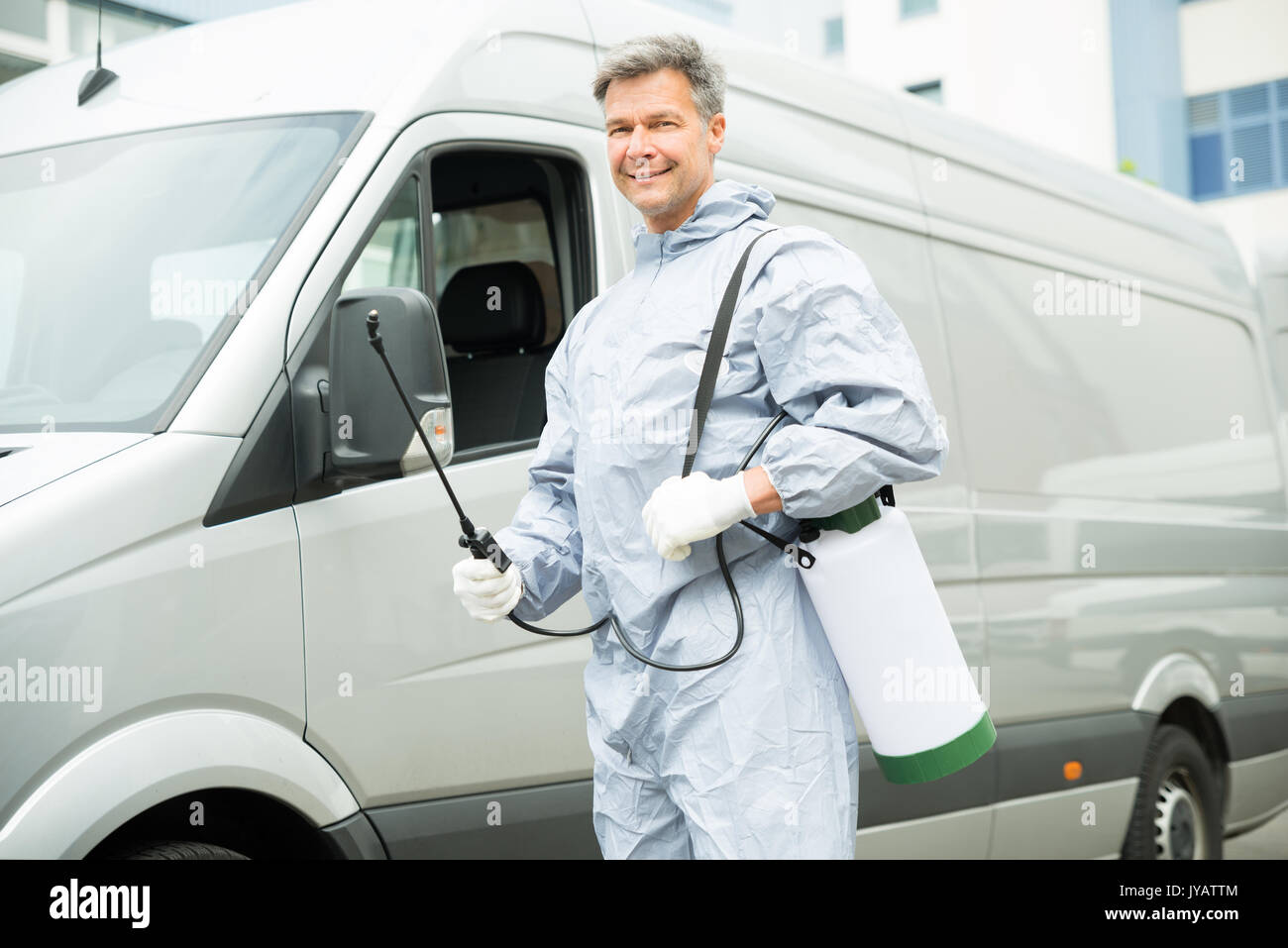 Happy Worker With Pesticide Sprayer Standing In Front Van Stock Photo