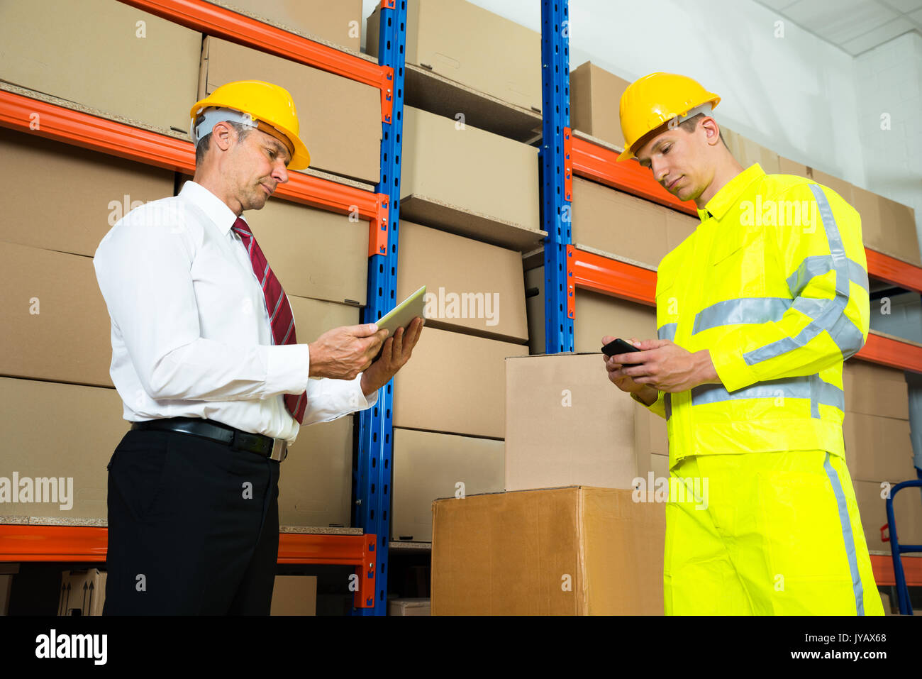 Warehouse Worker Checking The Inventory With Manager In A Large Warehouse Stock Photo