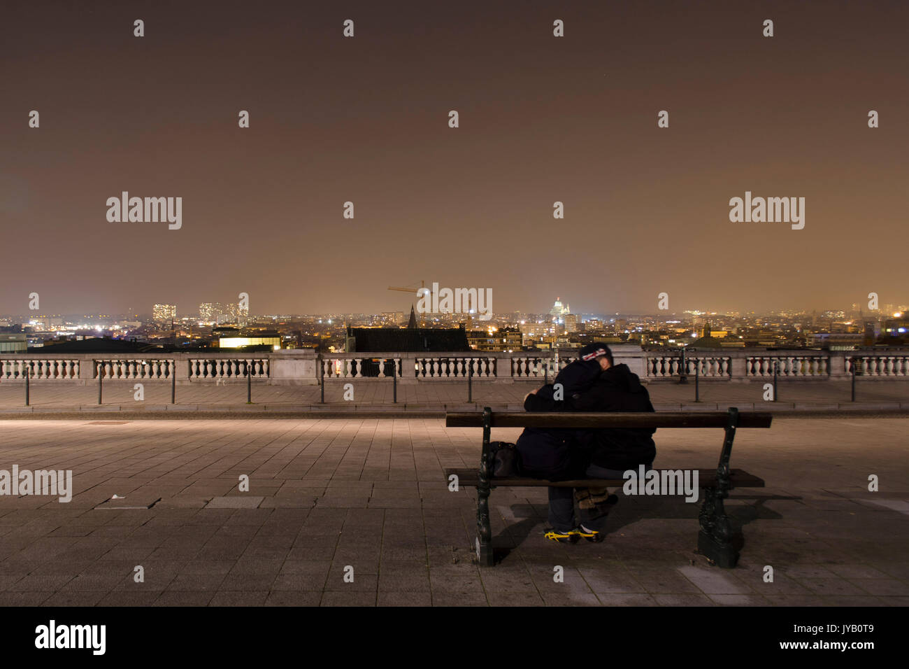 couple on a bench with romantic city view Stock Photo