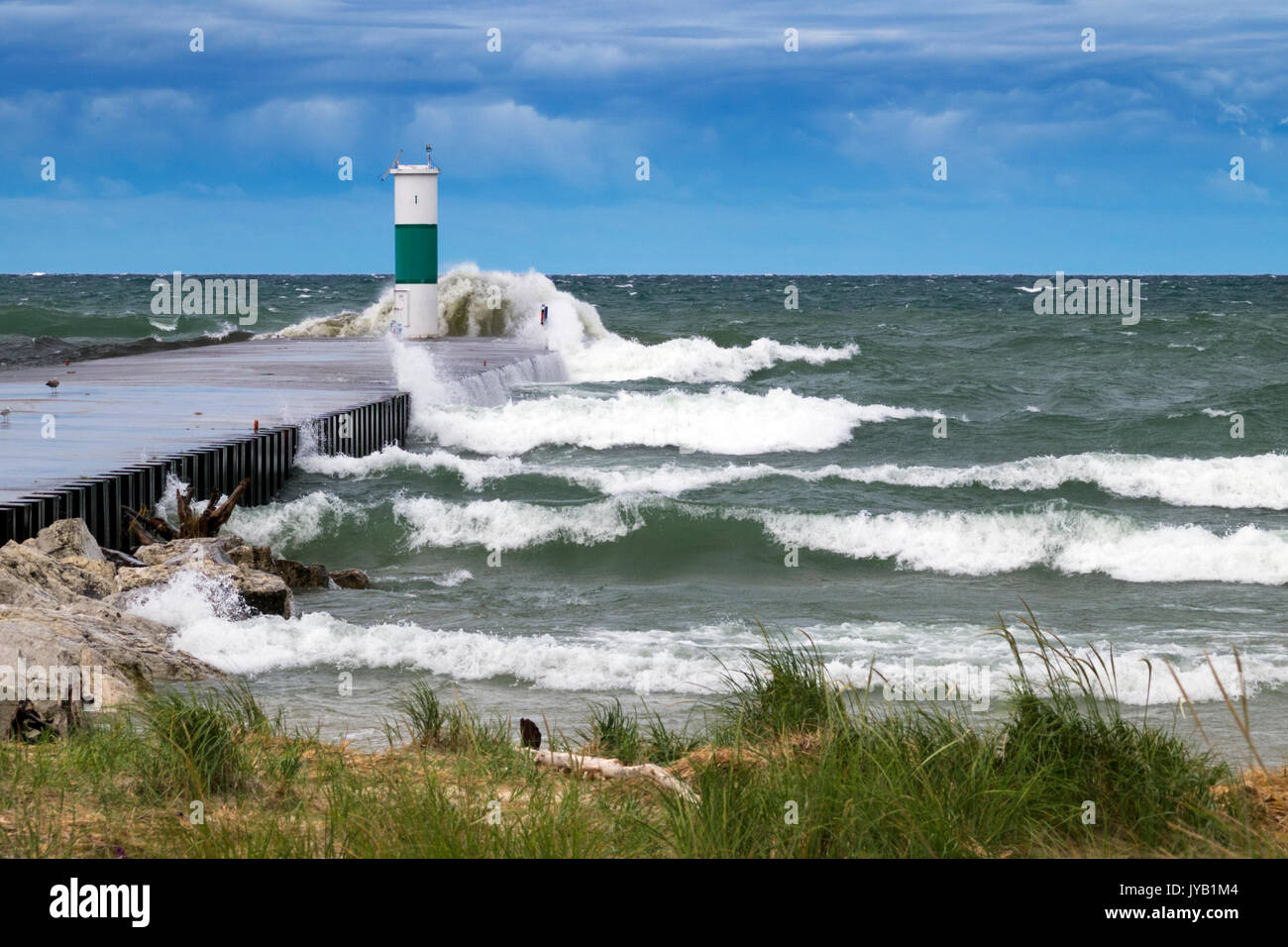 North pier and navigation light at the White Lake Channel taking a pounding from 6 and 7 foot waves rolling in from Lake Michigan. Stock Photo