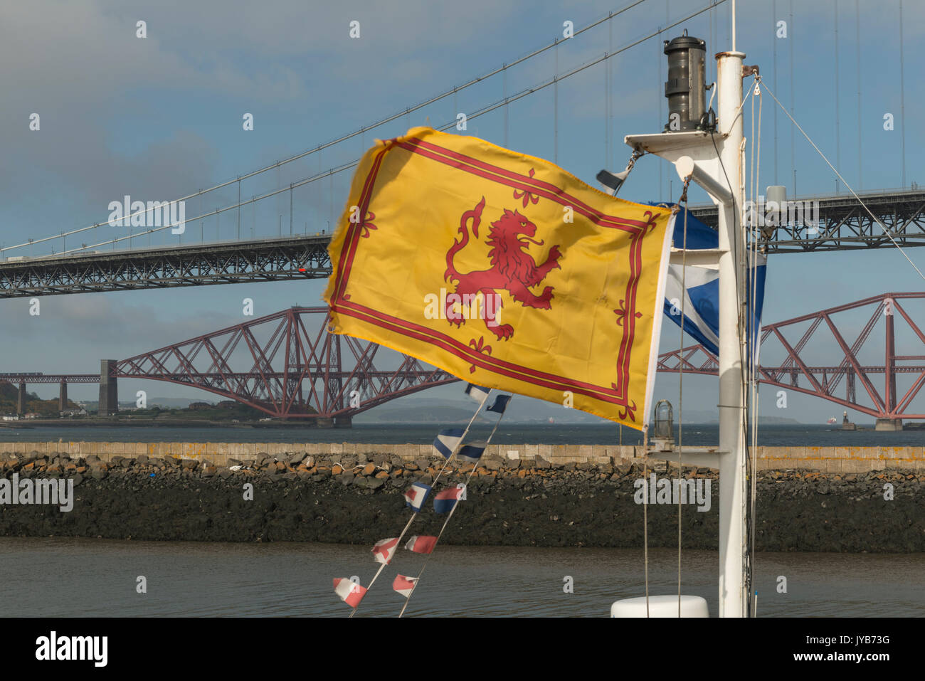 Scottish flags fly in front of iconic Scottish bridges, Firth of Forth, Scotland, UK Stock Photo