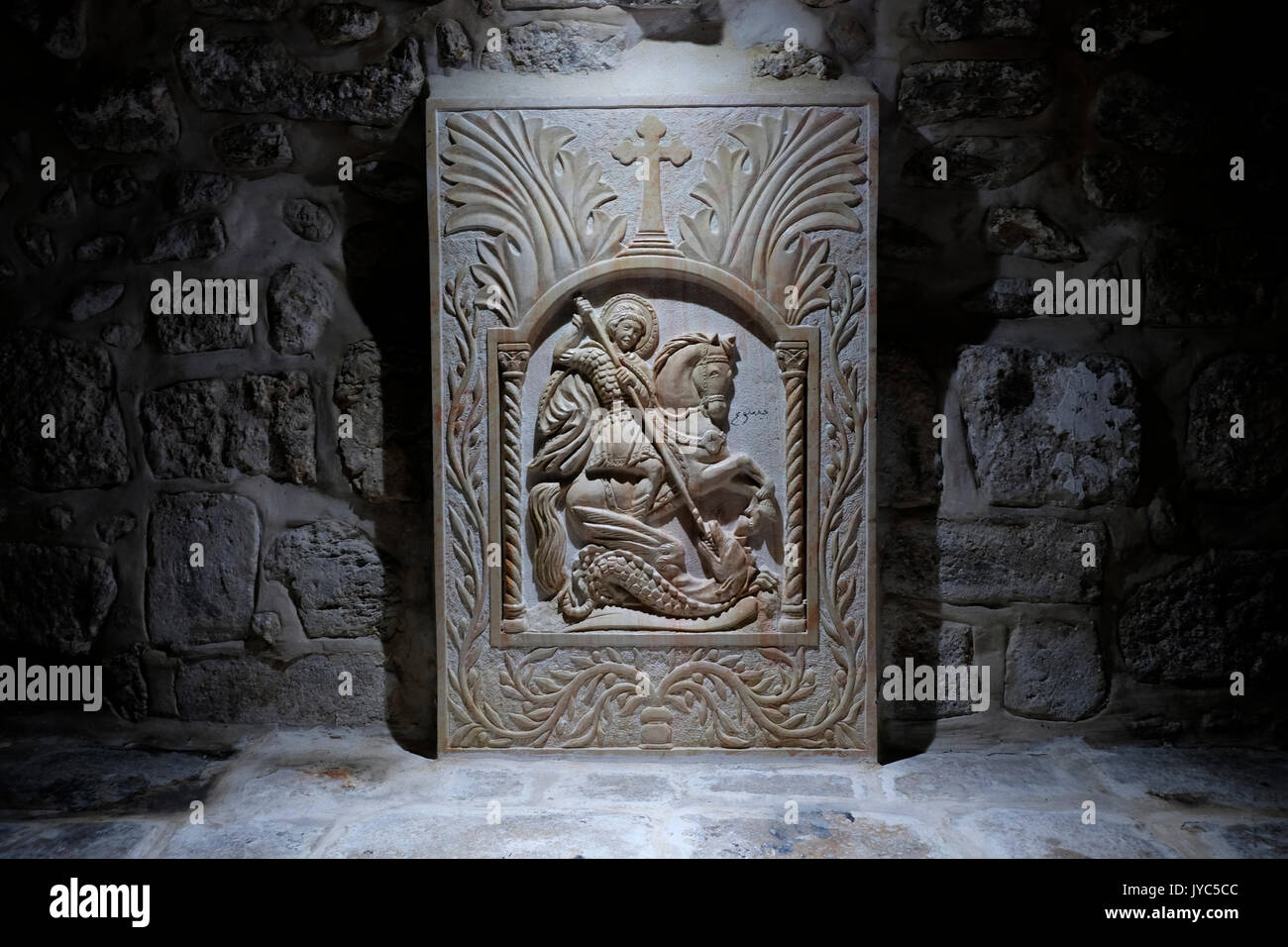 A carved figure depicting an orthodox Christian legend in which Saint George slays a dragon that demanded human sacrifices at the entrance to the St. George Monastery in Saint Francis street in the Christian Quarter old city East Jerusalem Israel Stock Photo