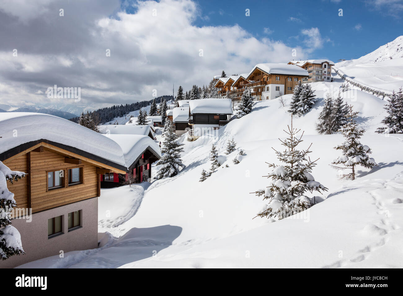 Trees covered with snow frame the typical mountain huts Bettmeralp district of Raron canton of Valais Switzerland Europe Stock Photo
