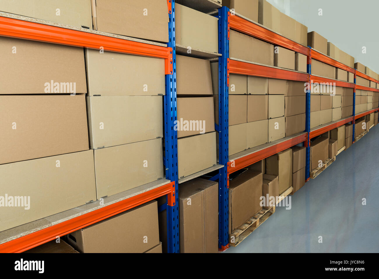 Cardboard Boxes On Shelves In Distribution Warehouse Stock Photo