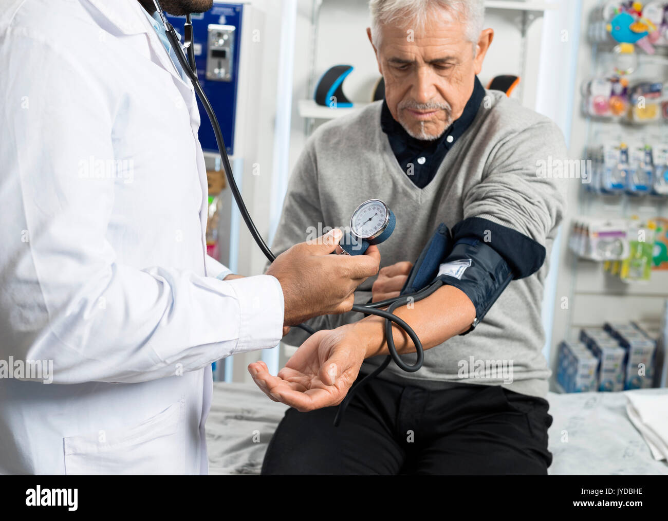 Midsection Of Male Chemist Checking Patient's Blood Pressure Stock
