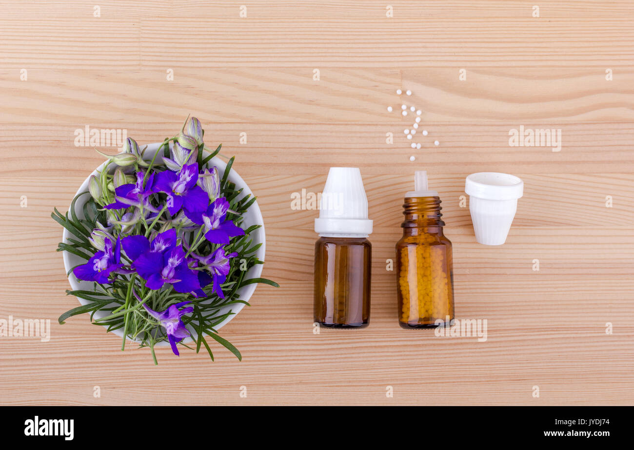 Homeopathic remedy with blooming aconite on a wooden background Stock Photo