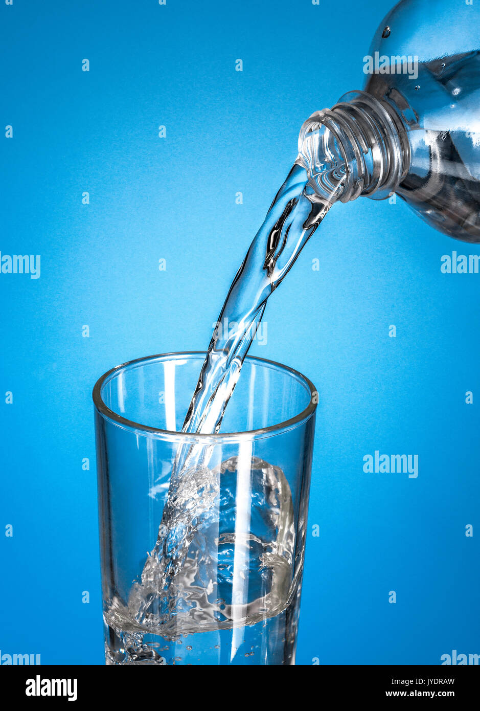 A Bottle Pouring Water in A Glass over Blue Stock Photo Alamy
