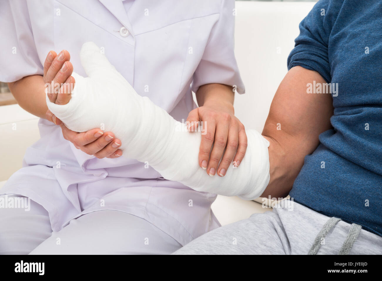 Close-up Of A Female Doctor Holding Fractured Hand Of A Patient Stock Photo