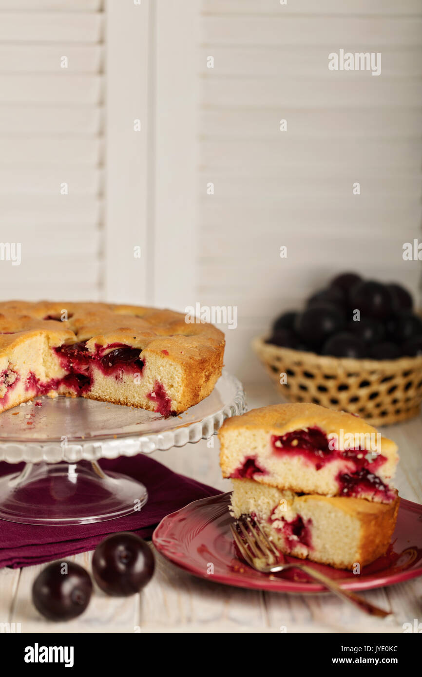 https://c8.alamy.com/comp/JYE0KC/homemade-plum-cake-on-a-glass-stand-selective-focus-JYE0KC.jpg