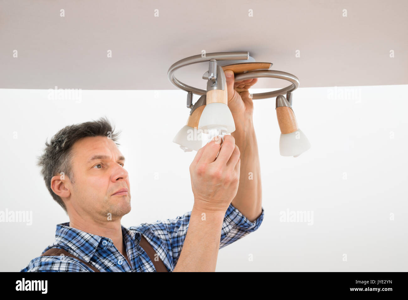 Portrait Of A Male Electrician Fixing Light On Ceiling Stock Photo - Alamy
