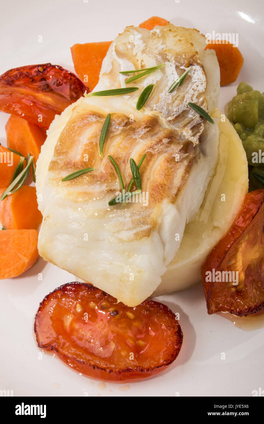 grilled cod with mashed potato, carrots, slice tomato and mushy pea ...