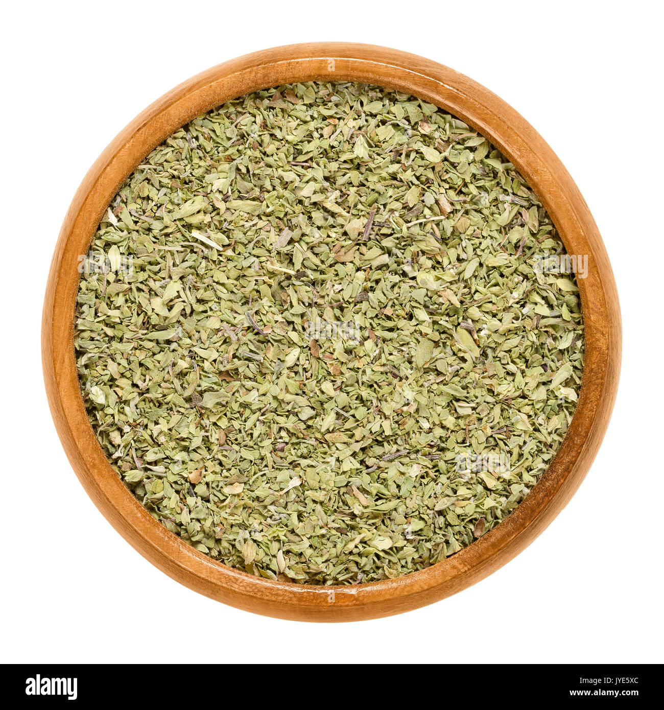 Oregano dried in wooden bowl. Origanum vulgare, sometimes wild marjoram. Herb with aromatic olive green leaves and a slightly bitter taste. Stock Photo
