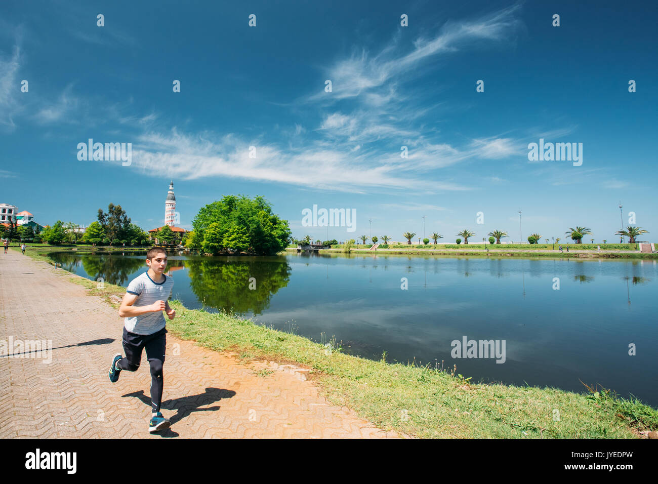 Batumi, Adjara, Georgia - May 25, 2016: Man athlete jogging on a summer sunny day near Ardagani Lake In Batumi, Adjara, Georgia. Stock Photo