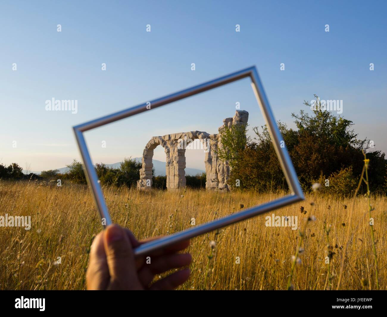 Burnum in Croatia ex roman ancient stone wall picture image frame framed hand hold holding Stock Photo