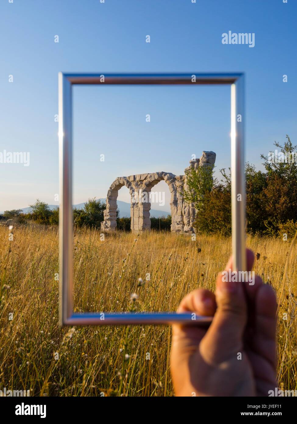 Burnum in Croatia ex roman ancient stone wall picture image frame framed hand hold holding Stock Photo