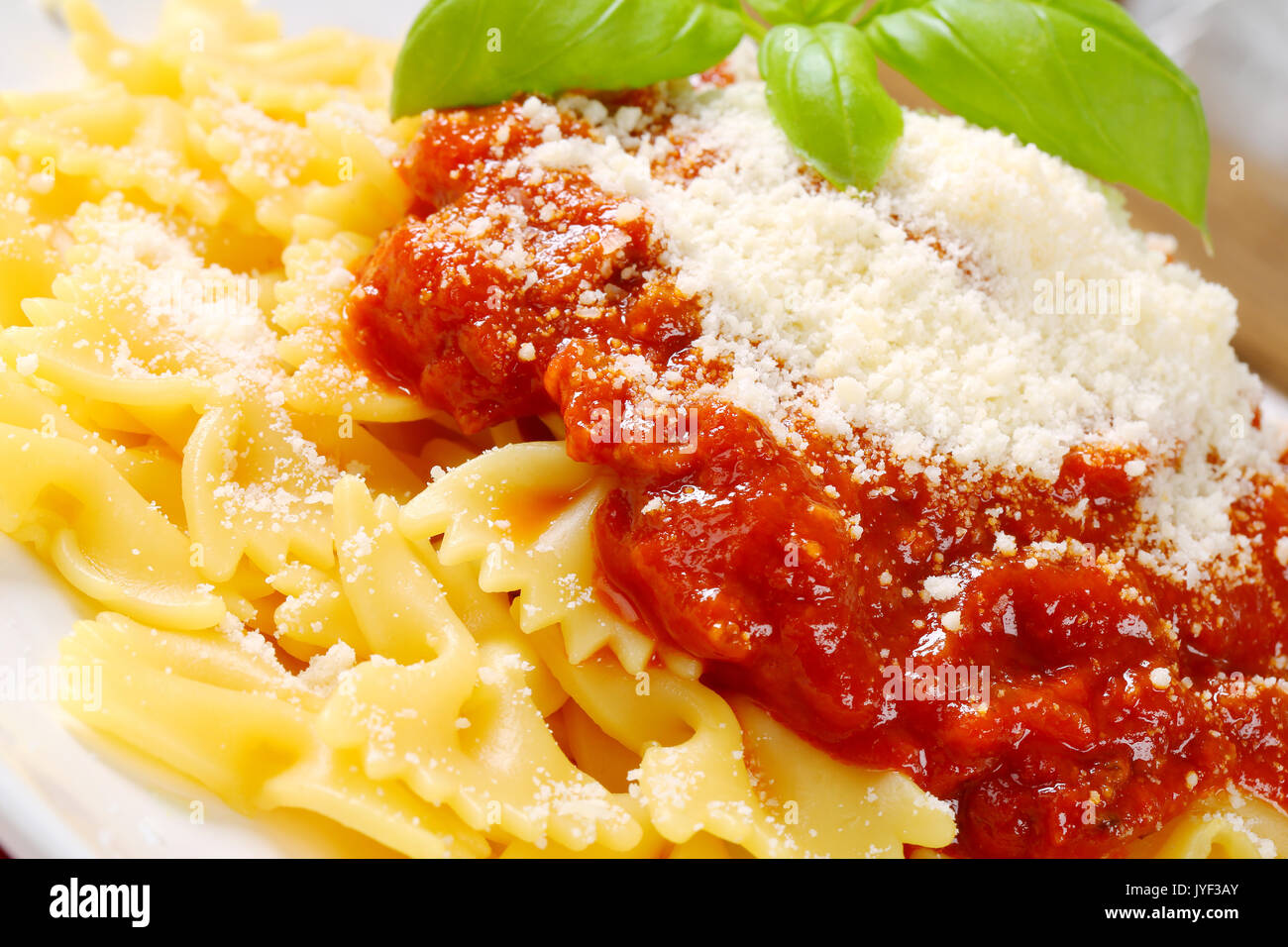 Bowtie pasta with thick tomato sauce and parmesan Stock Photo Alamy