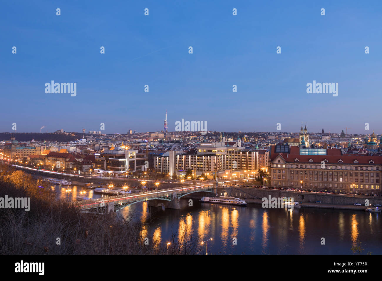 Dusk lights up the historical bridges and buildings reflected on Vltava (Moldava) river Prague Czech Republic Europe Stock Photo