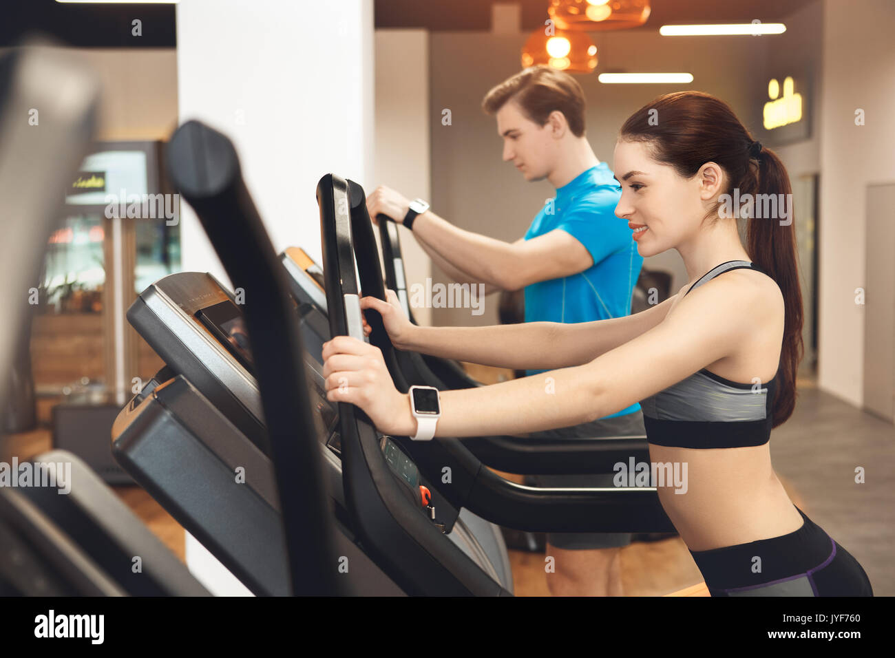 Young man and woman training in gym body workout cardio Stock Photo - Alamy