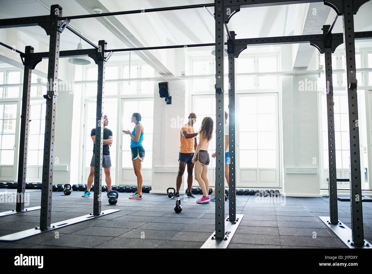 Two friends in sportswear high fiving each other while talking together in gym after a workout Stock Photo