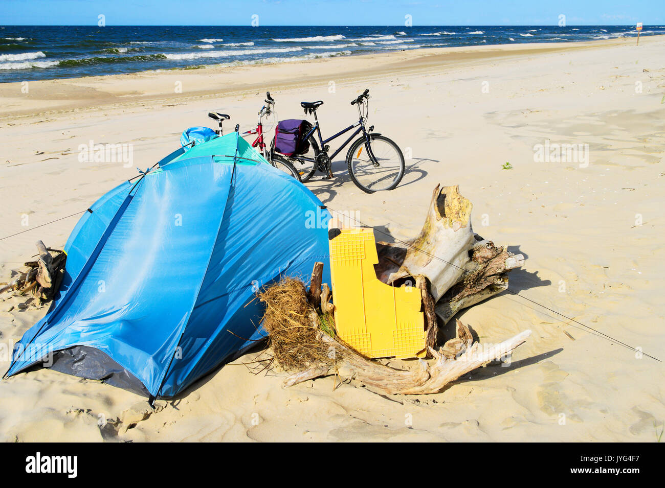 Blue tent and bicycles on wild deserted sandy beach. Camp at the Baltic sea coast. Bicycle tourism. Stegna, Pomerania, Poland. Stock Photo