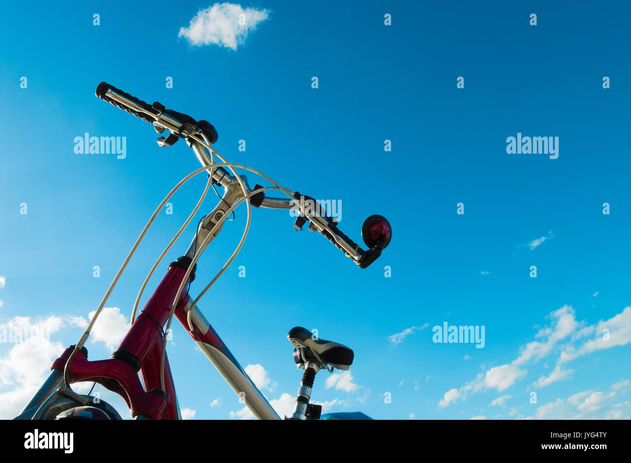 Bicycle upper part with handlebar and frame against blue sky. Bicycle tourism. Stock Photo