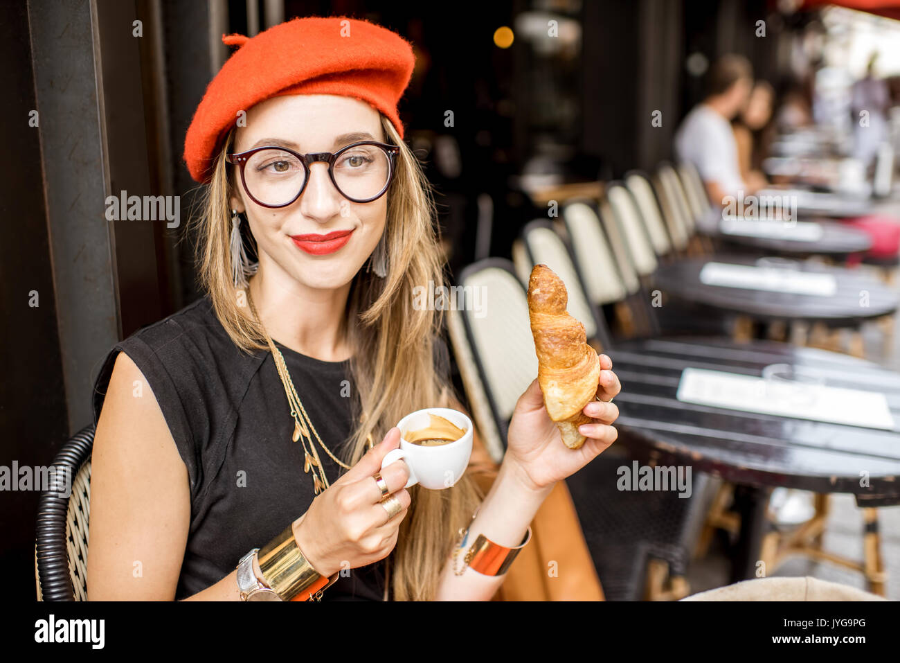 Woman having a french breakfast at the cafe Stock Photo