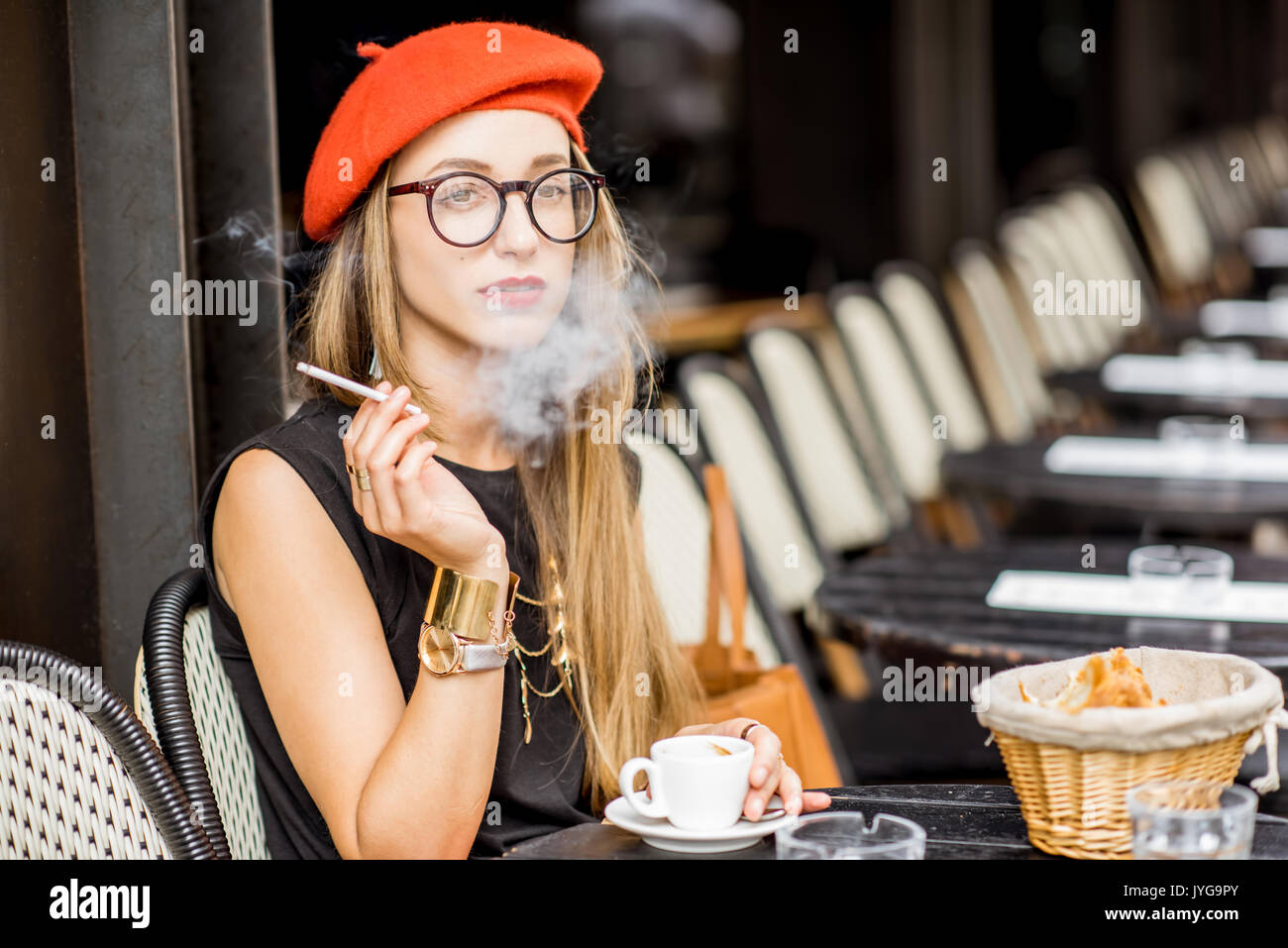 French woman smoking at the cafe Stock Photo