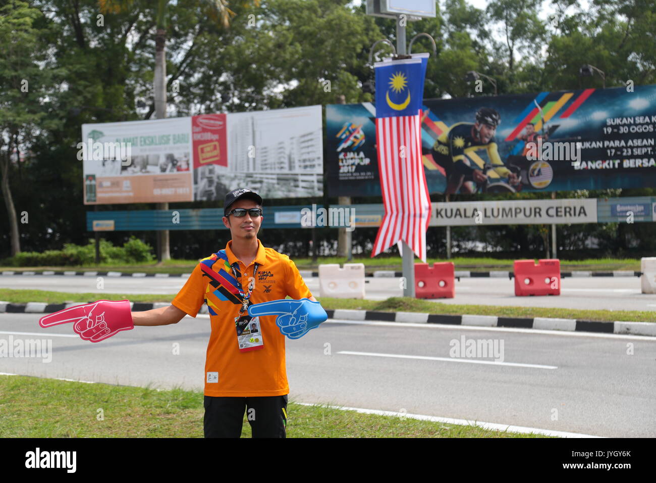 Kuala Lumpur, Malaysia. 19th August, 2017. Young volunteer giving direction to stadium hosting the opening ceremony of 29th SEA games. Credit: Calvin Chan/Alamy Live News Stock Photo