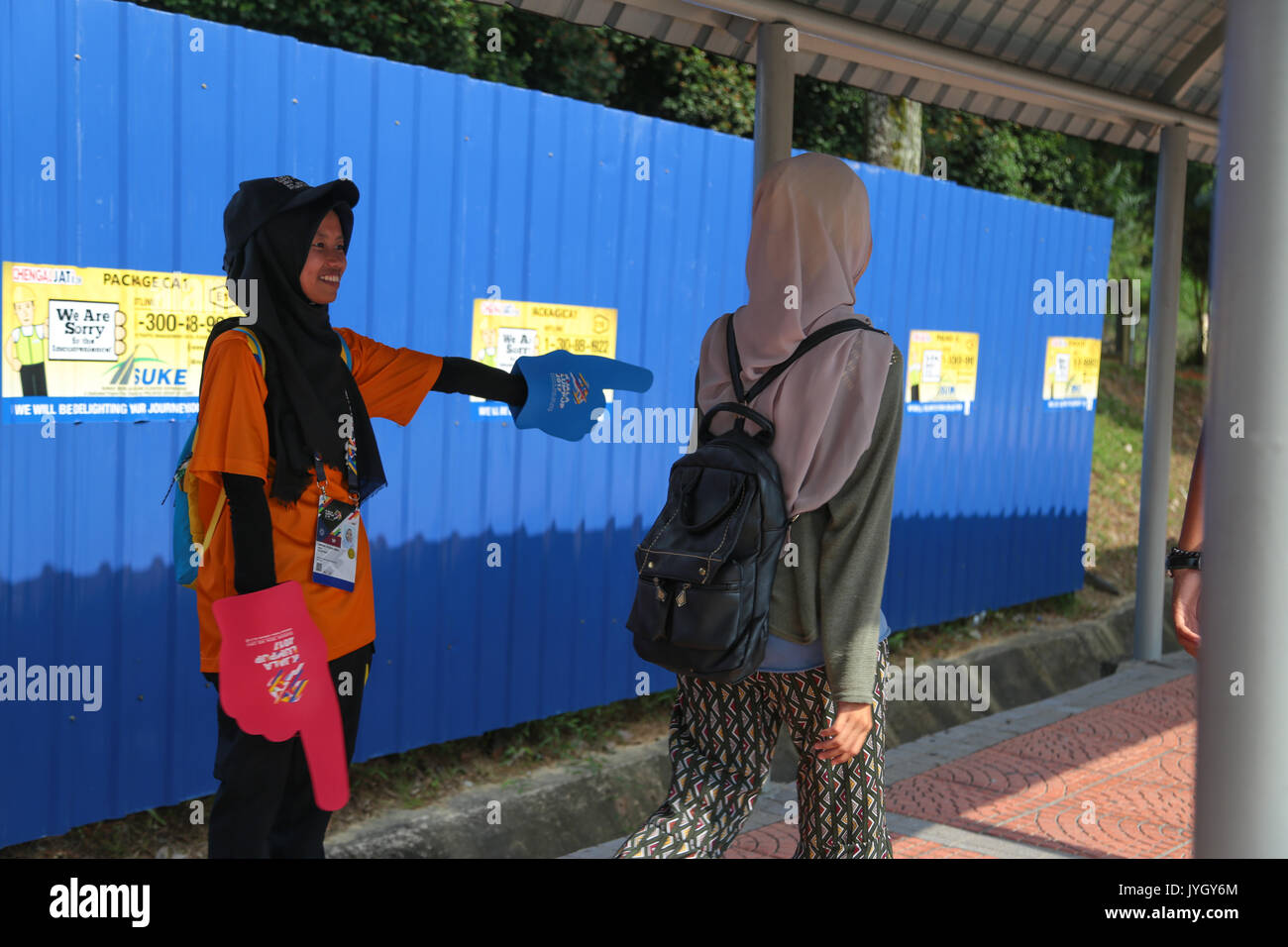 Young volunteer giving direction to stadium hosting the opening ceremony of 29th SEA games. Credit: Calvin Chan/Alamy Live News Stock Photo