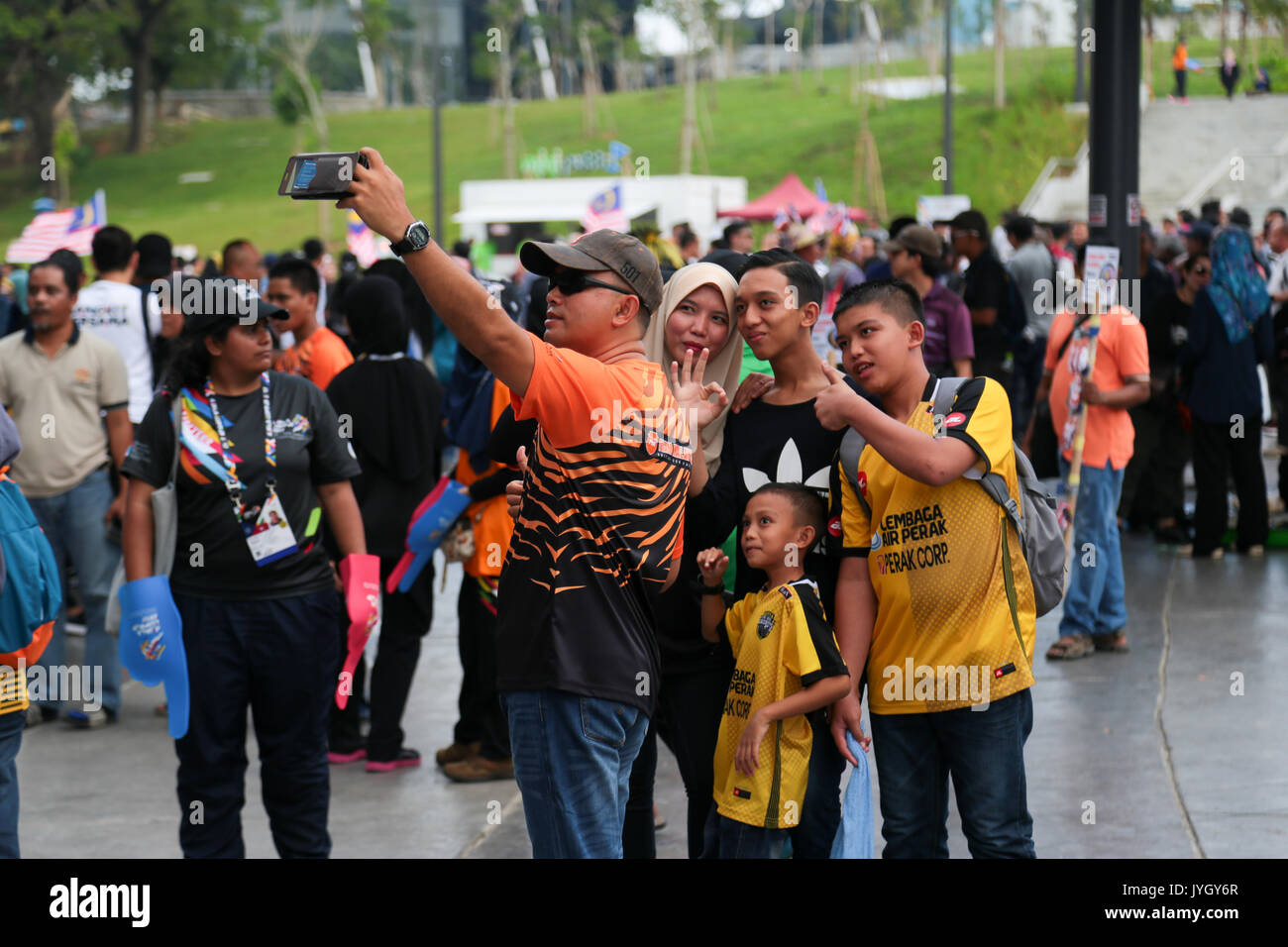 Family using smartphone to take group photo outside the National stadium hosting the 29th SEA games. Credit: Calvin Chan/Alamy Live News Stock Photo